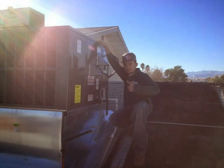 HVAC technician performing Air Duct Repair on a rooftop unit in Orlando